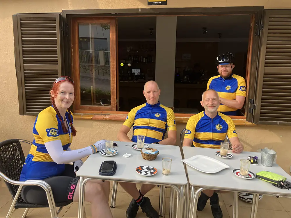 Three club members relaxing at a cafe on a training camp